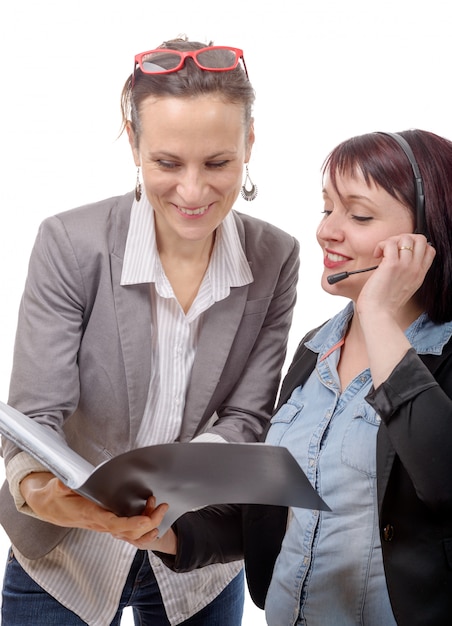 Due giovani donne sorridenti che lavorano insieme al taccuino