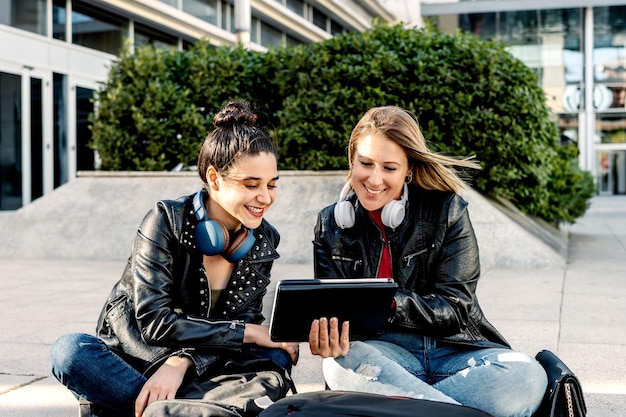 Due giovani freelance stanno usando un tavolino esterno