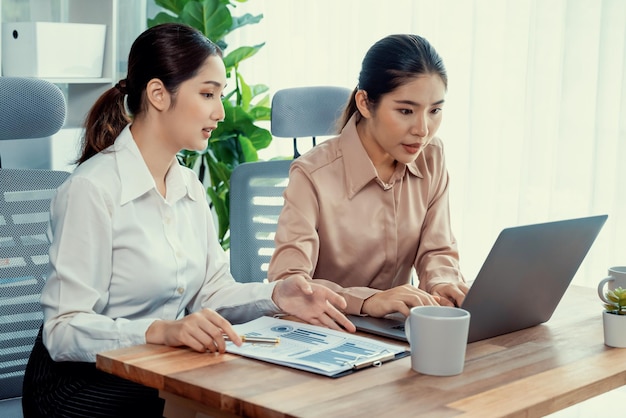 Due giovani imprenditrici lavorano insieme nell'area di lavoro dell'ufficio Entusiasta