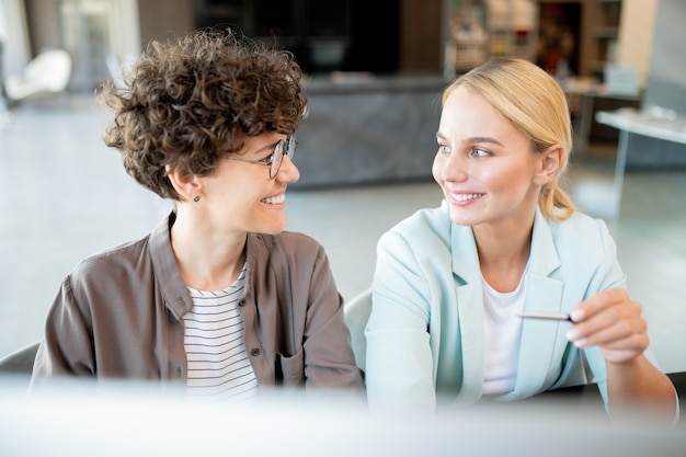 Due giovani manager di successo che discutono di nuove idee durante il brainstorming alla riunione di lavoro