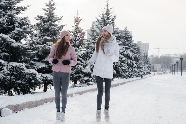 Due giovani ragazze atletiche che corrono nel parco in una giornata invernale di sole. Uno stile di vita sano.