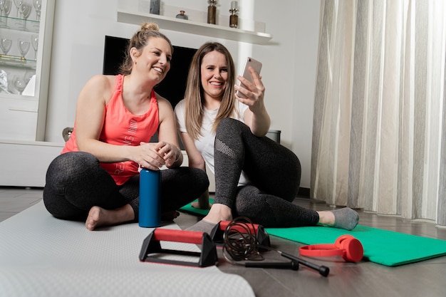 Due giovani ragazze che parlano in videochiamata dopo aver praticato sport a casa.