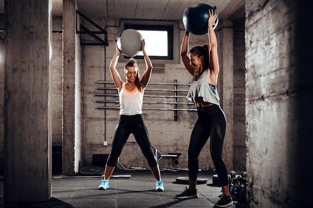 Due giovani ragazze muscolose che si allenano insieme in palestra.