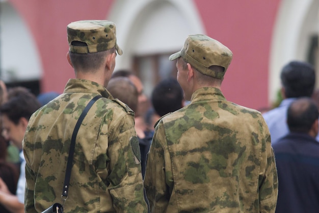 Due giovani soldati in abiti militari che camminano per la strada della città