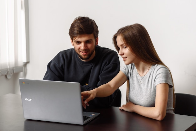 due giovani sono seduti al computer