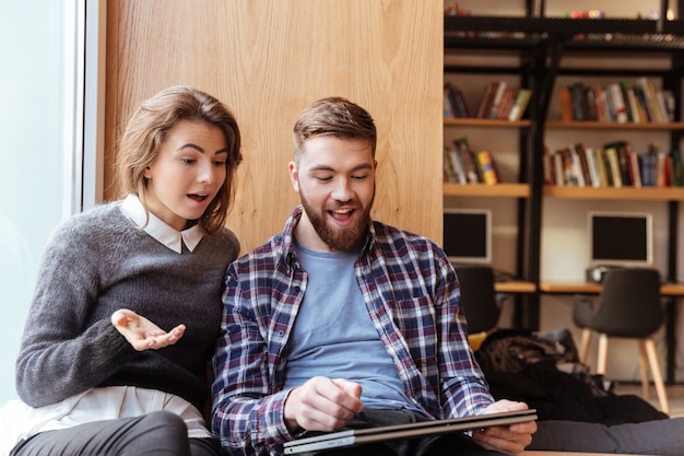 Due giovani studenti che utilizzano computer tablet