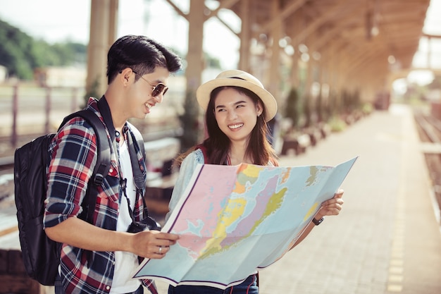 Due giovani turisti asiatici con zaini con mappa