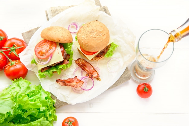 Due hamburger serviti con un bicchiere di soda cola