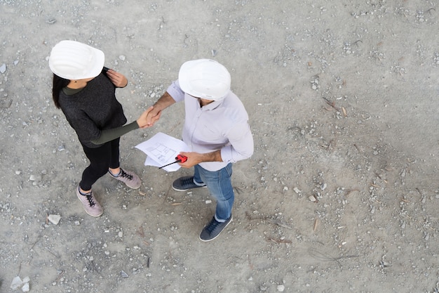 Due ingegnere che fa la stretta di mano nel cantiere edile.