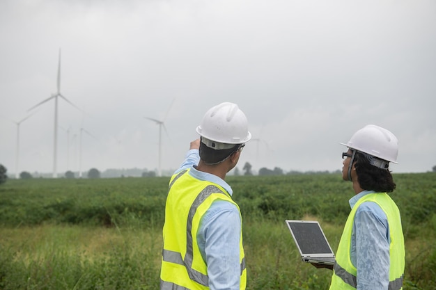 Due ingegneri che lavorano e tengono il rapporto presso l'azienda agricola di turbine eoliche Power Generator Station sulla gente di mountainThailand