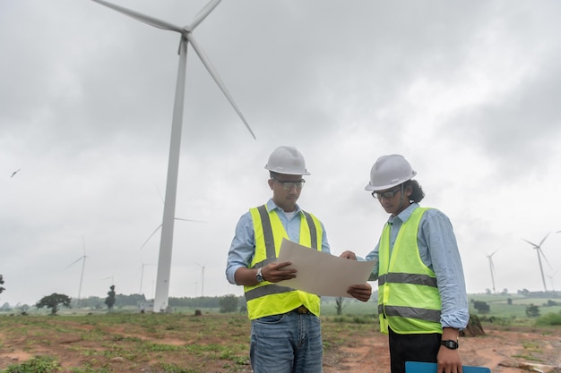 Due ingegneri che lavorano e tengono il rapporto presso l'azienda agricola di turbine eoliche Power Generator Station sulla gente di mountainThailand