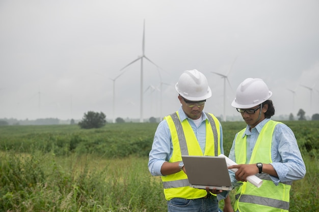 Due ingegneri che lavorano e tengono il rapporto presso l'azienda agricola di turbine eoliche Power Generator Station sulla gente di mountainThailand