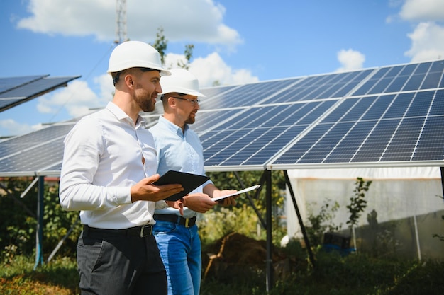 Due ingegneri stanno conducendo un'ispezione esterna dei pannelli solari fotovoltaici.