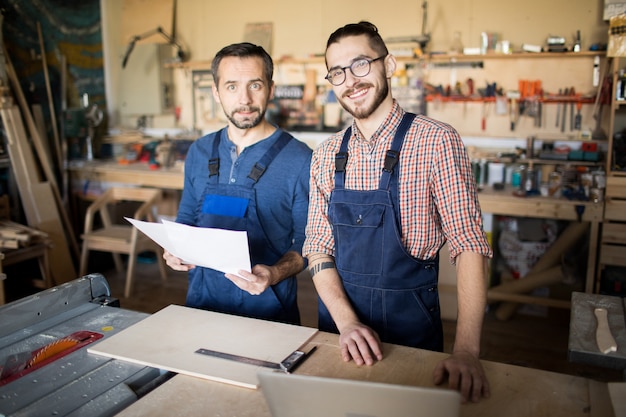 Due lavoratori in posa nel negozio di falegnameria