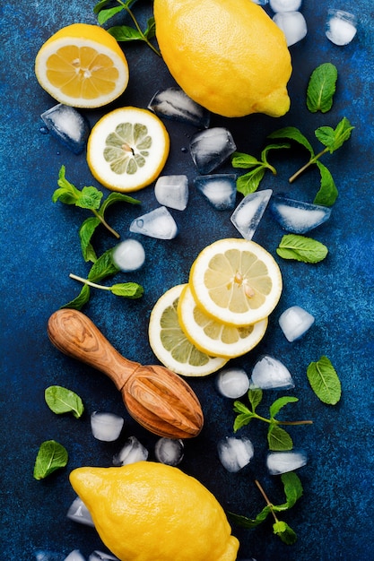 Due limoni freschi nel piatto blu scuro sulla superficie del calcestruzzo turchese