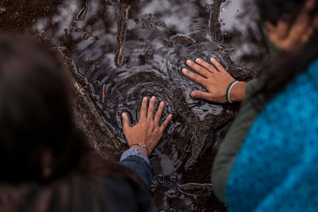Due mani di donne innamorate che toccano insieme la superficie dell'acqua Concetto ambiente giornata della terra