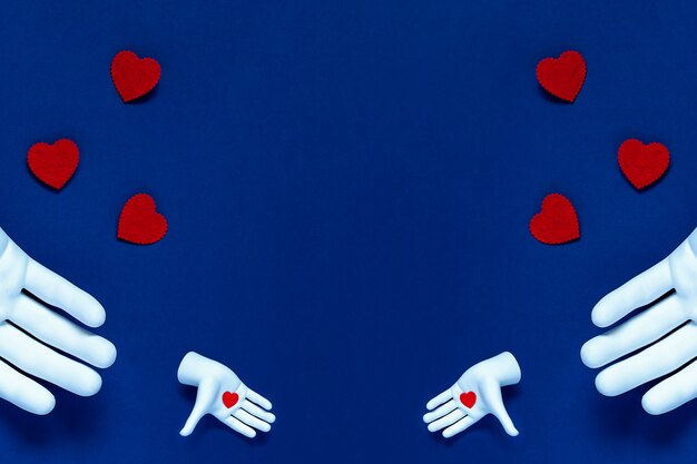 Due mani lanciano cuori rossi su sfondo blu. Il concetto per San Valentino