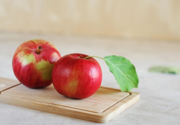 Due mele rosse giacciono su una tavola di legno