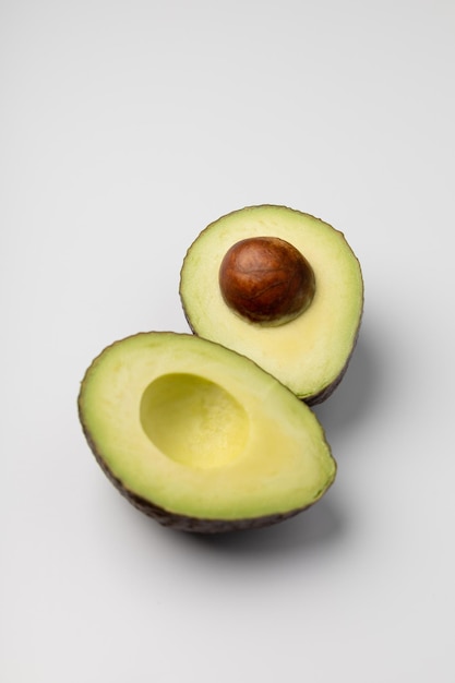 Due metà di avocado fresco su sfondo bianco