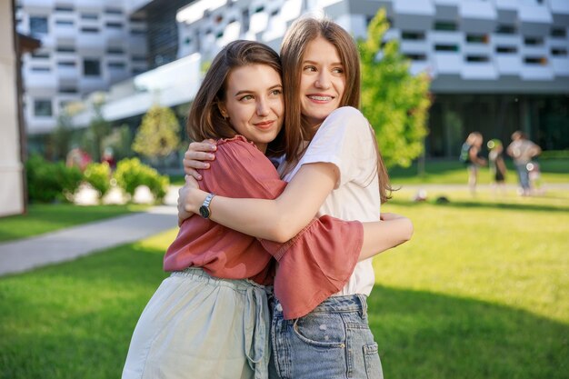 Due migliori amiche di ragazze carine e felici si abbracciano in natura