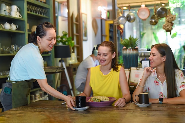 Due migliori amici che parlano e mangiano in un caffè.