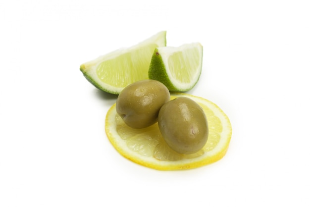 Due olive e un pezzo di limone e lime isolato su bianco