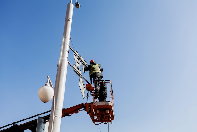 Due operai cambiano la segnaletica stradale