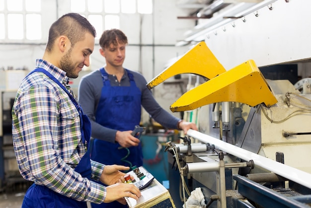 Due operai che lavorano su una macchina