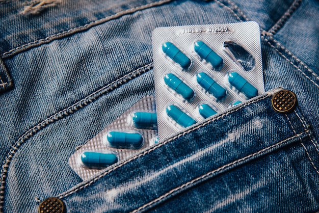 Due pacchetti di capsule blu nella tasca dei pantaloni. Pillole per la salute degli uomini