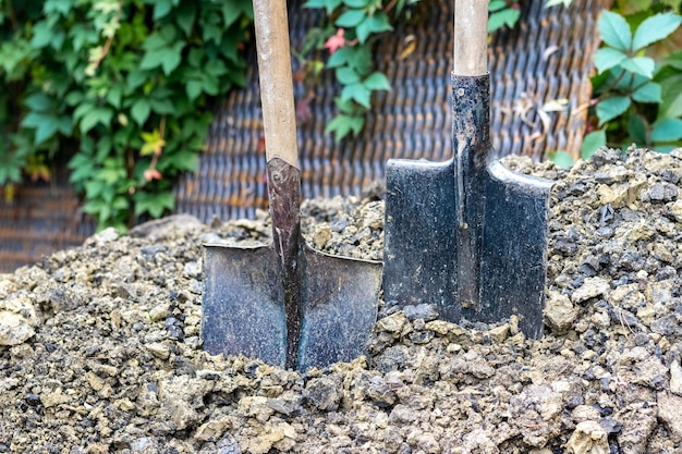 Due pale conficcate nel terreno, un mucchio di terra e una paletta