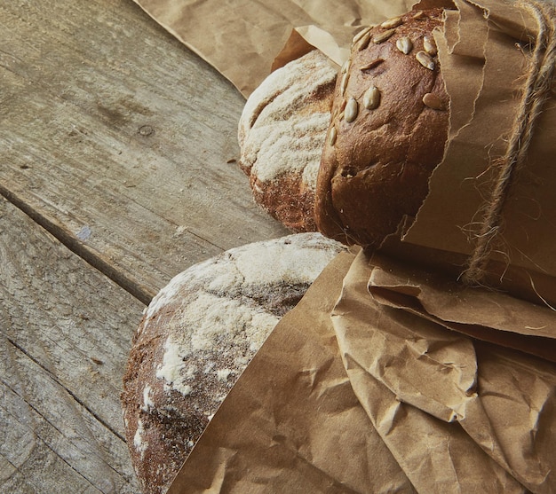 Due pani confezionati in carta su tavola di legno