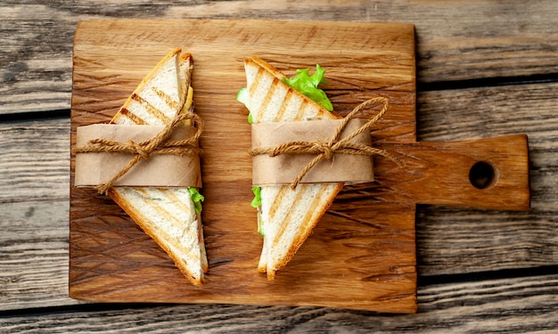 Due panini su un tagliere su uno sfondo di legno in stile rustico.