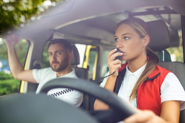 Due paramedici nell'ambulanza Paramedico femminile che guida un'ambulanza che parla alla radio Situazione urgente