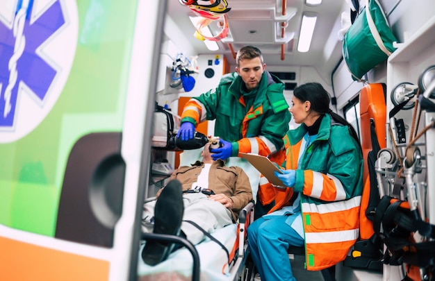Due paramedici professionisti in un'ambulanza con un paziente in barella