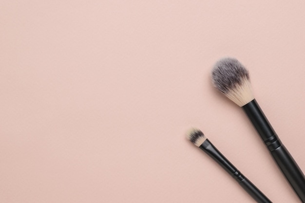 Due pennelli per il trucco su uno sfondo beige chiaro Cosmetici moderni popolari Posa piatta