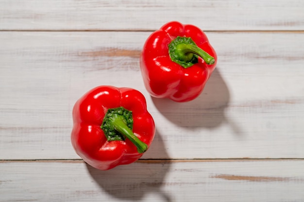 Due peperoni rossi su fondo in legno Sfondo chiaro Concetto di cibo vegetariano