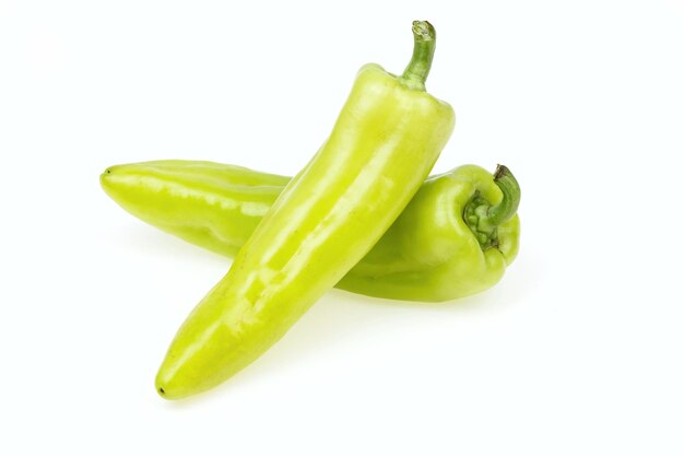 Due peperoni verdi a punta su sfondo bianco