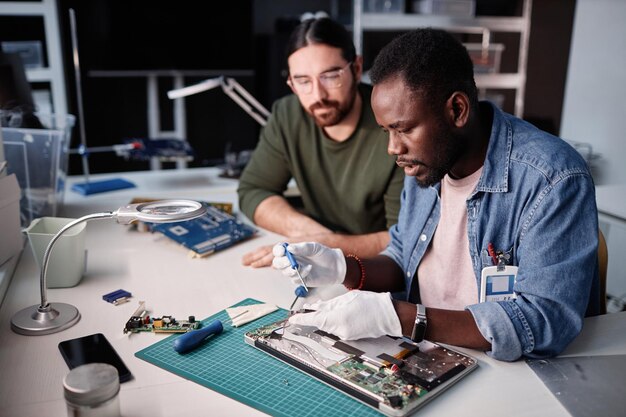 Due persone che riparano il computer nella riparazione tecnica