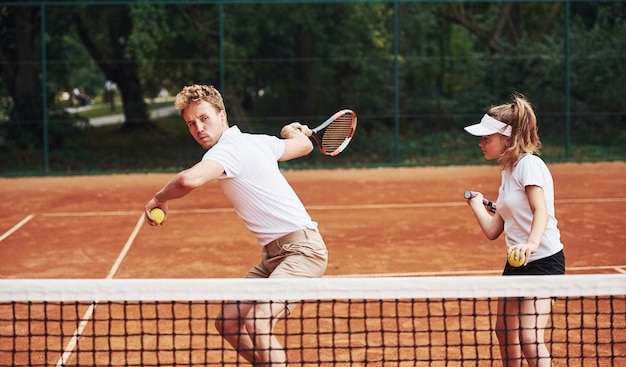 Due persone in divisa sportiva giocano a tennis insieme sul campo.