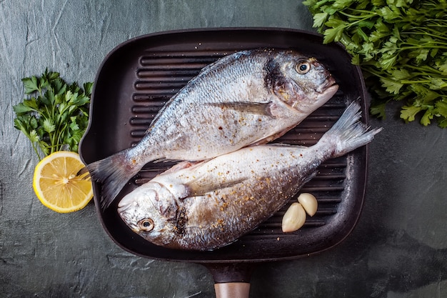 Due pesci crudi di dorado con spezie e limone.