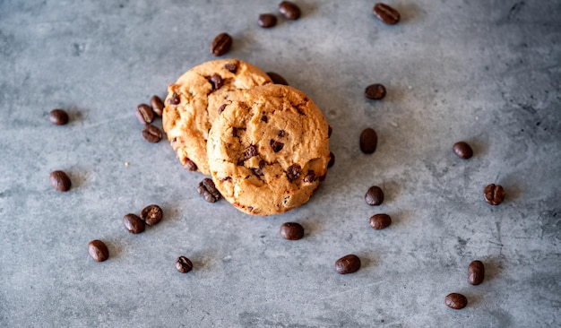 Due pezzi di biscotti con chicchi di caffè su sfondo grigio