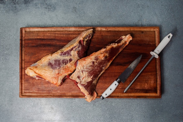 Due pezzi di carne posti su una tavola di legno.