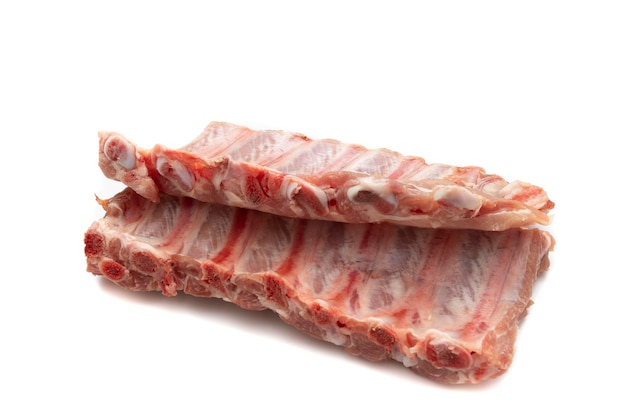 Due pezzi di costolette di maiale crude isolati su sfondo bianco Carne molto richiesta per barbecue