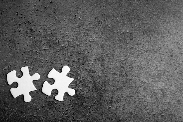 Due pezzi di puzzle bianco su sfondo grigio