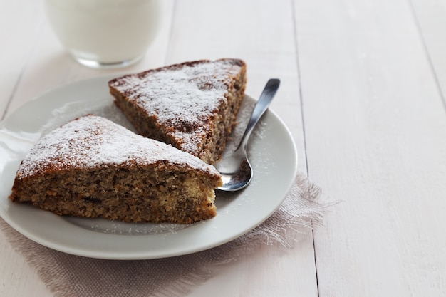 Due pezzi di torta con zucchero in polvere sul piatto