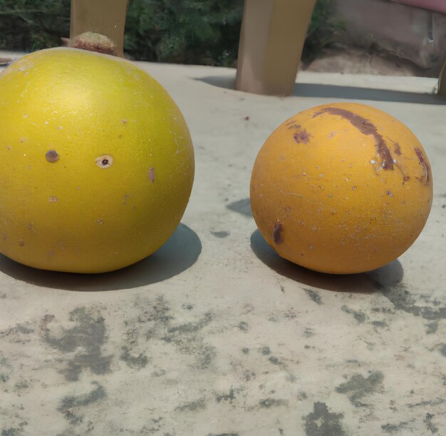 Due piccole arance siedono su una superficie di cemento.