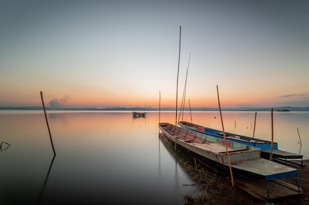 Due piccole imbarcazioni ormeggiate in riva al lago. al tramonto bella luce