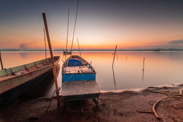 Due piccole imbarcazioni ormeggiate in riva al lago. al tramonto bella luce