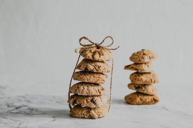 Due pile di biscotti di farina d'avena al mirtillo rosso legati con un packthread