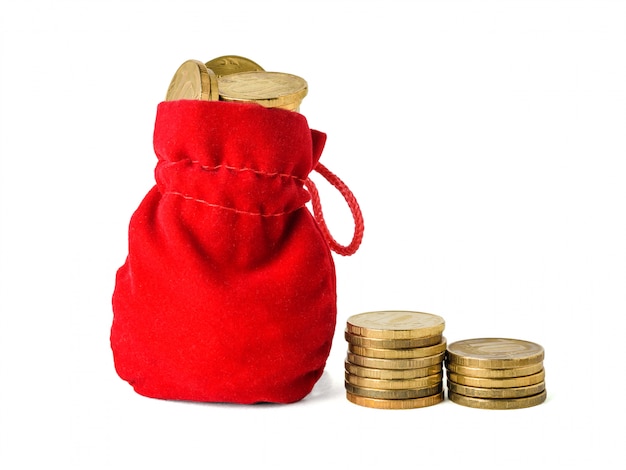 Due pile di monete e una borsa rossa hanno riempito di monete isolate su bianco. Il concetto di risparmio di denaro contante.